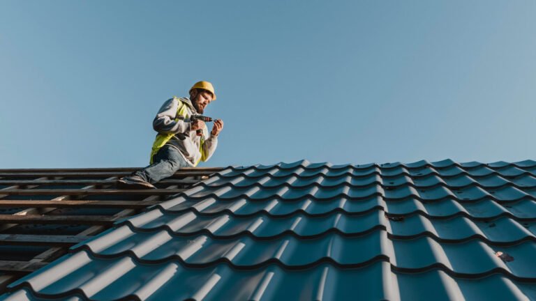 un operaio controlla il tetto di una casa ed esegue alcune riparazioni